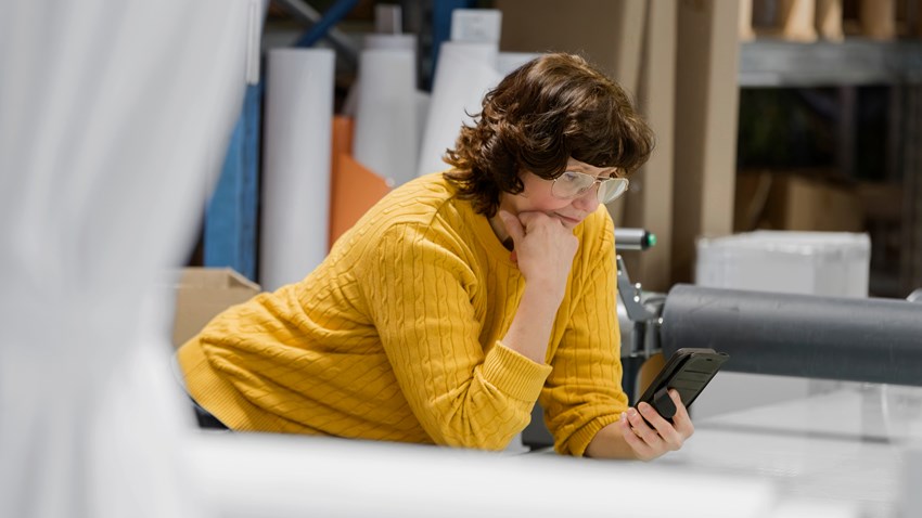 En kvinna sitter vid ett skrivbord och jobbar
