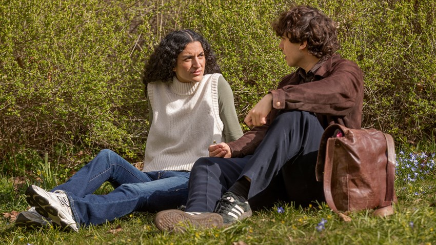 En man och en kvinna sitter i gräset