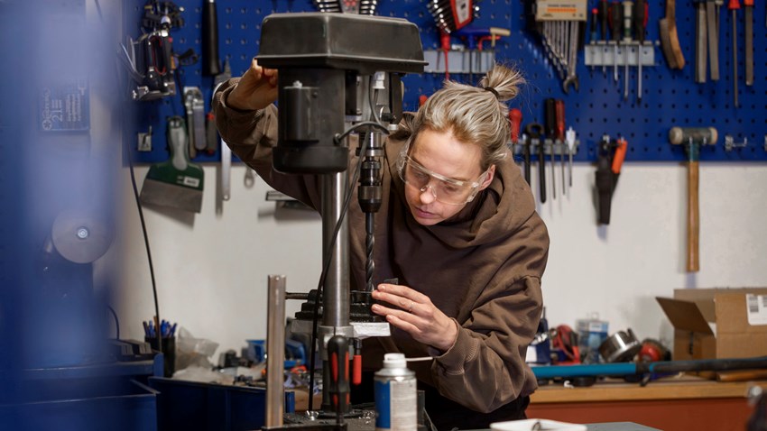 En kvinna som arbetar på en maskin i en butik.