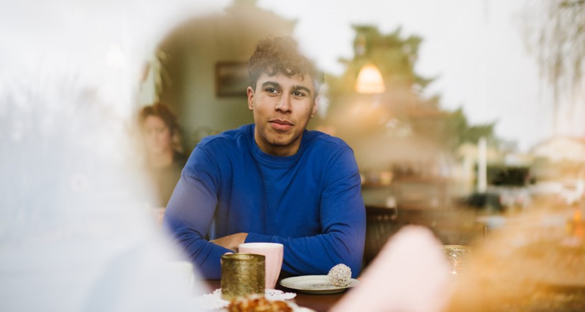 En man sitter ensam vid ett cafébord.